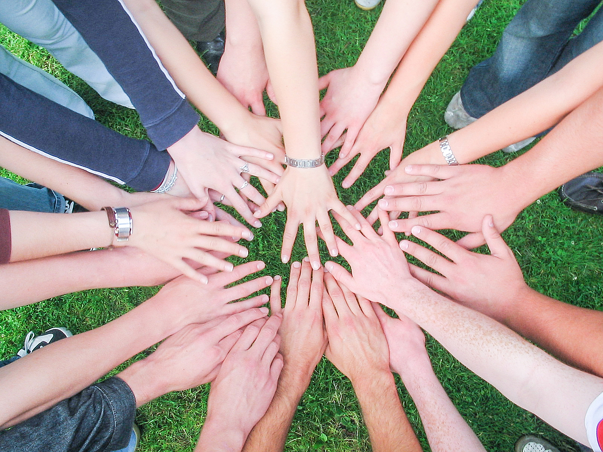 Händen finden im Kreis zusammen als Symbol für Teamwork