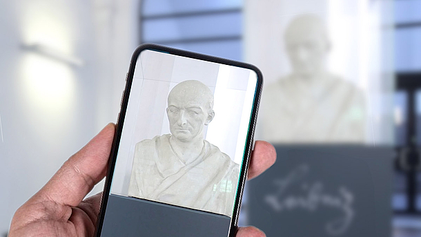 Leibniz-Büste im Lichthof des Welfenschlosses wird mit dem Handy fotografiert