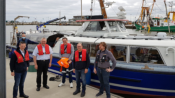 Wissenschaftsminister Björn Thümler steht mit Akteuren des Projekts "Gute Küste Niedersachsen" vor dem Forschungsboot Otzum