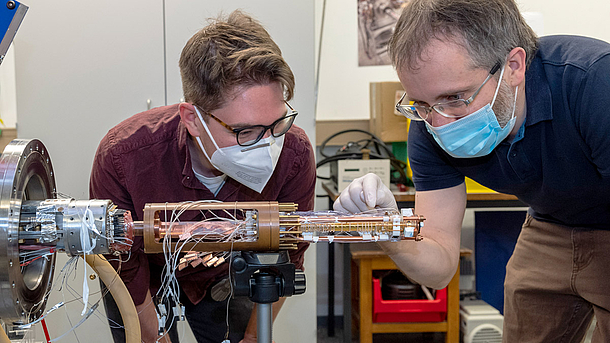 Zwei Wissenschaftler der Universität Mainz installieren eine Penningfalle