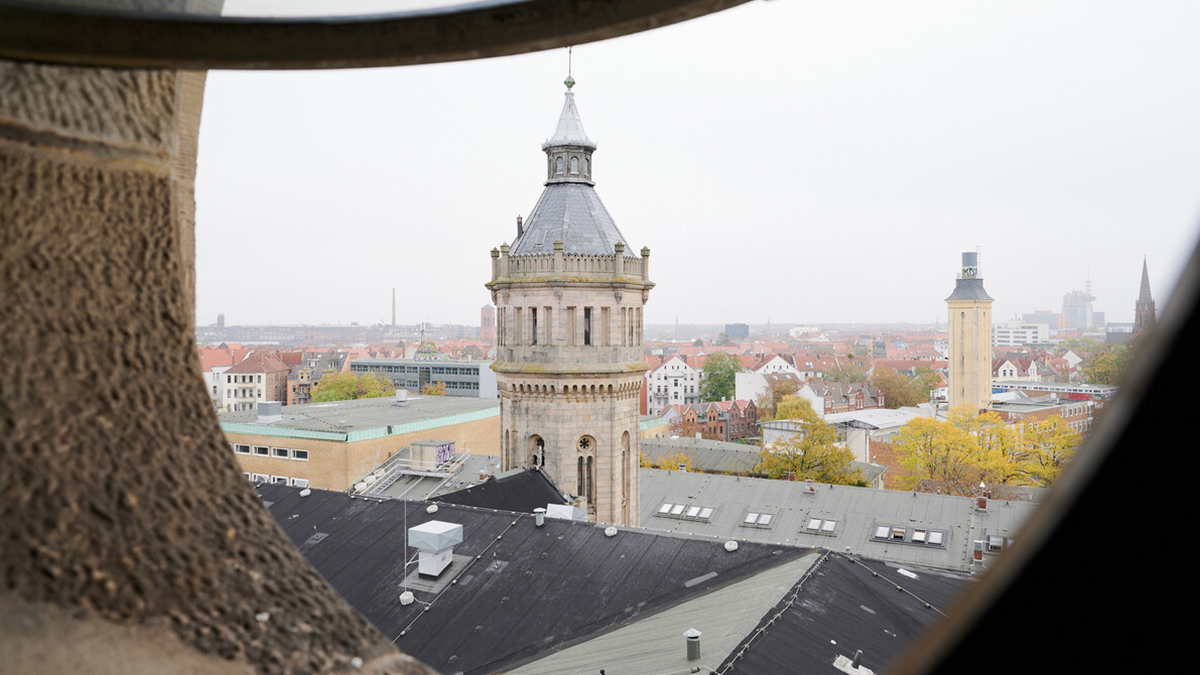 Ausblick durch das Turmzimmer auf einen niedrigeren Turm des Welfenschlosses und umliegende Gebäude