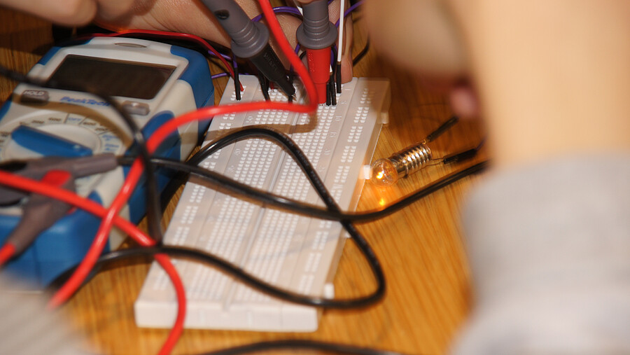 A person works on an electrical circuit.