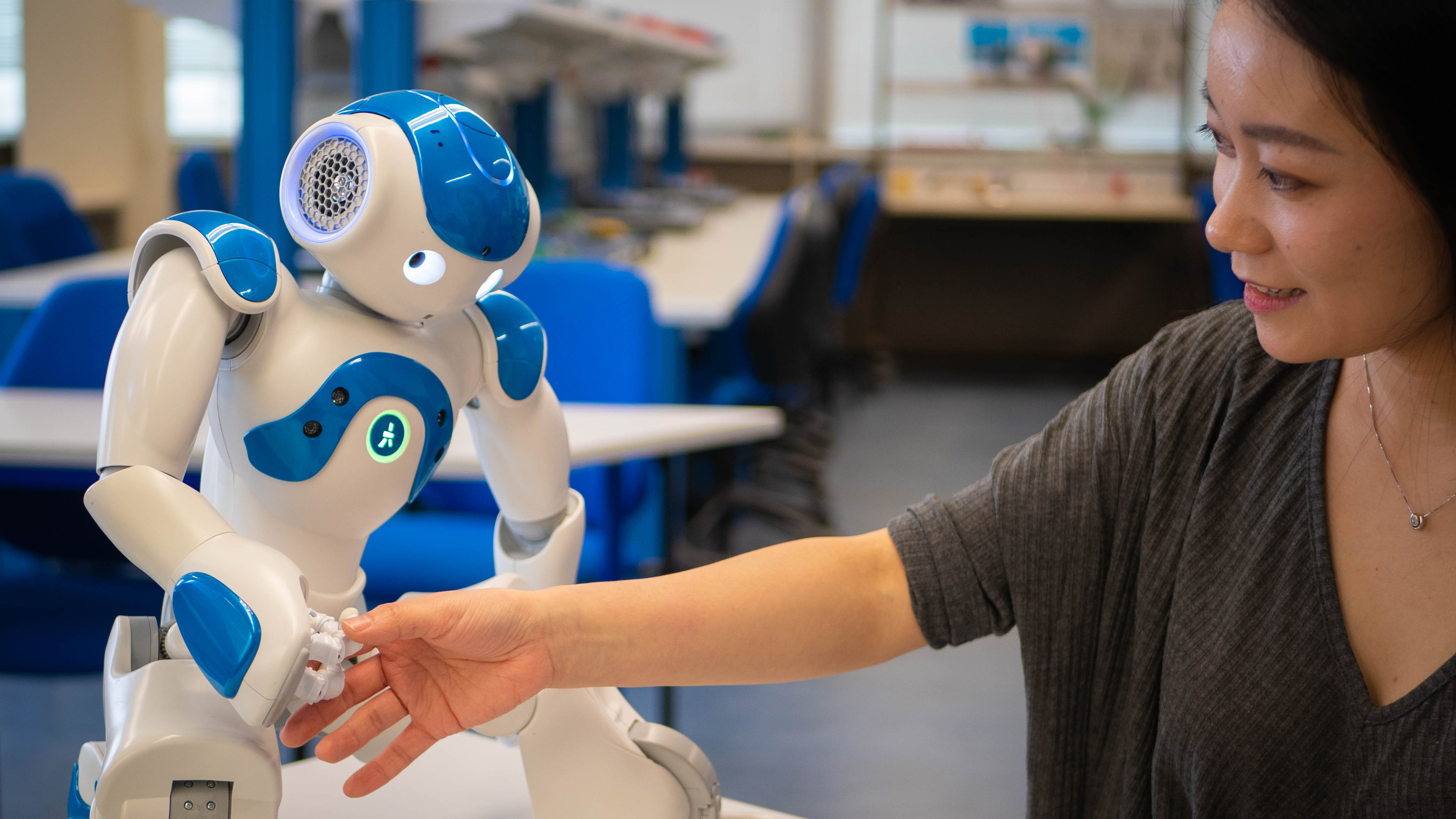 A person works on a robot.