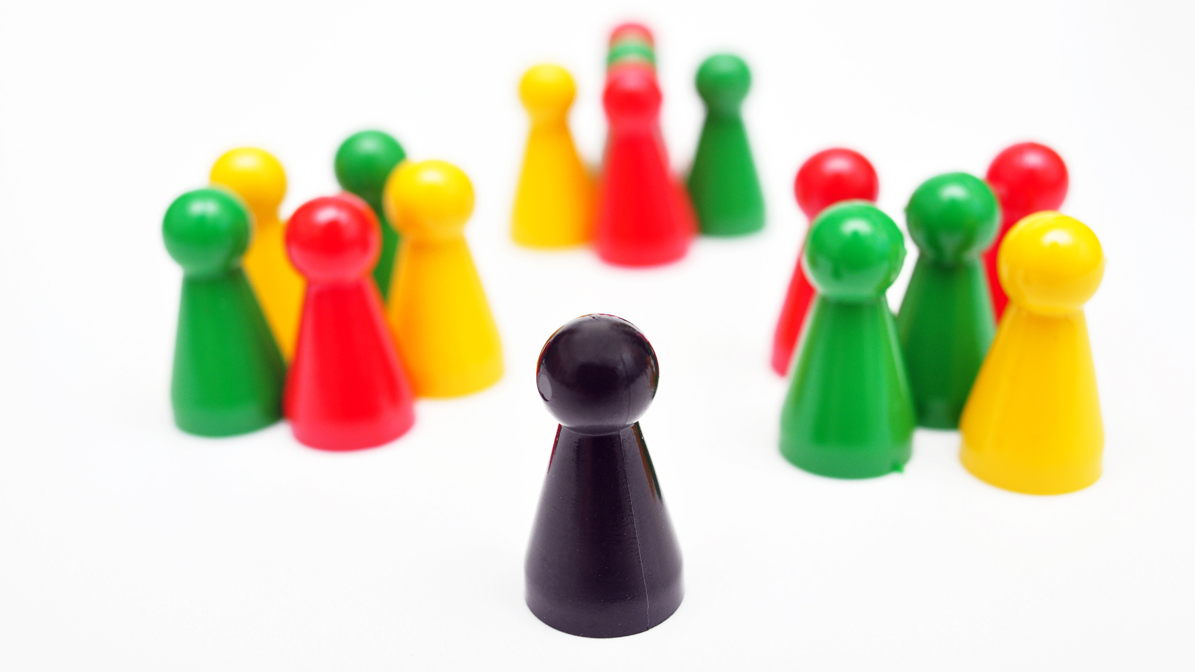 In the background there are three groups with differently colored pawns and in the foreground there is a black pawn alone.