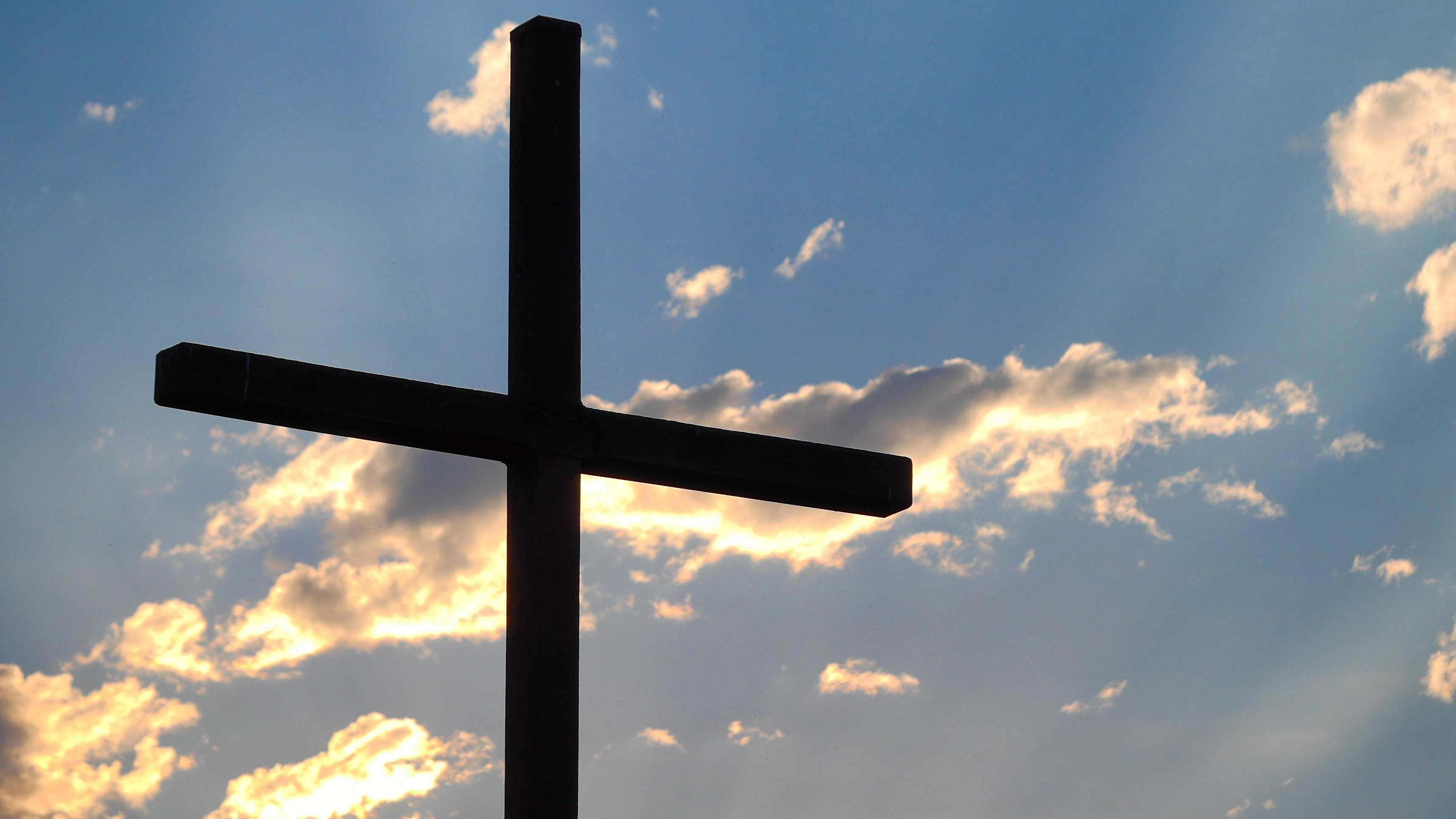 A cross with the sky in the background.